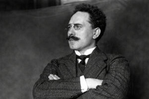 Karl Liebknecht, schwarz-weißes Porträt im Anzug mit Brille und Schnurrbart, seitlich blickend, Arme verschränkt (frühes 20. Jahrhundert)