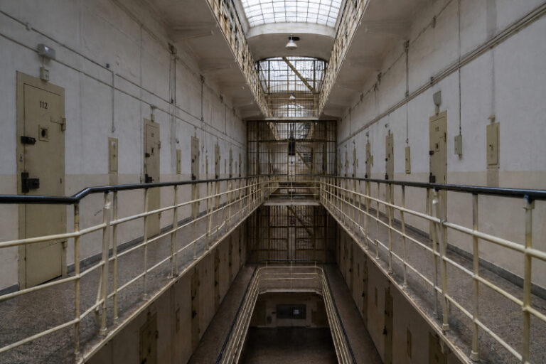 DDR Unrecht Entschädigung: Innenansicht einer DDR-Haftanstalt mit Gefängniszellen, langen Gängen und vergitterten Türen als Symbol politischer Verfolgung in der DDR