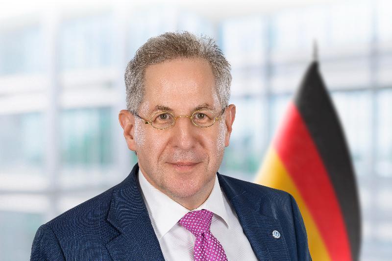 Hans-Georg Maaßen: Wenn der Staat seinen obersten Schützer ins Visier nimmt 3 Porträt von Hans-Georg Maaßen vor Deutschlandfahne