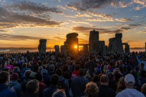 Menschenmenge feiert die Sommersonnenwende bei Sonnenaufgang am Steinkreis
