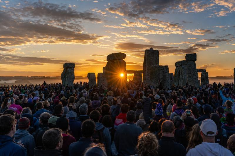 Menschenmenge feiert die Sommersonnenwende bei Sonnenaufgang am Steinkreis