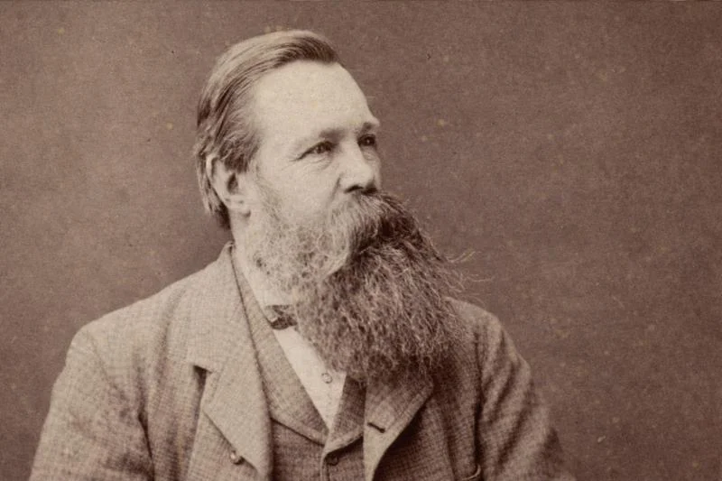 Friedrich Engels: Der Soldat und Revolutionär im Visier der preußischen Geheimpolizei 1 Porträt von Friedrich Engels im Sepia-Ton im 16:9-Format, mit langem Bart und Anzug, nach rechts blickend vor neutralem Hintergrund.