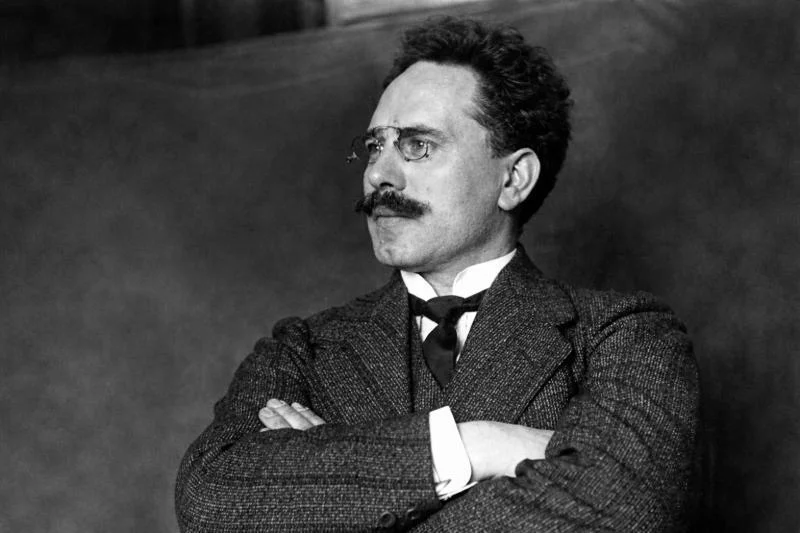 Karl Liebknecht, schwarz-weißes Porträt im Anzug mit Brille und Schnurrbart, seitlich blickend, Arme verschränkt (frühes 20. Jahrhundert)